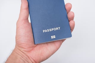 Hand holding blue passport