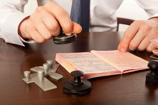 Person stamping a passport with visa