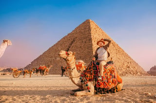 Happy tourist riding camel at Giza