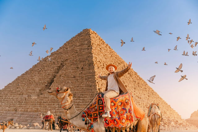 Tourist Man With Hat Riding On Camel